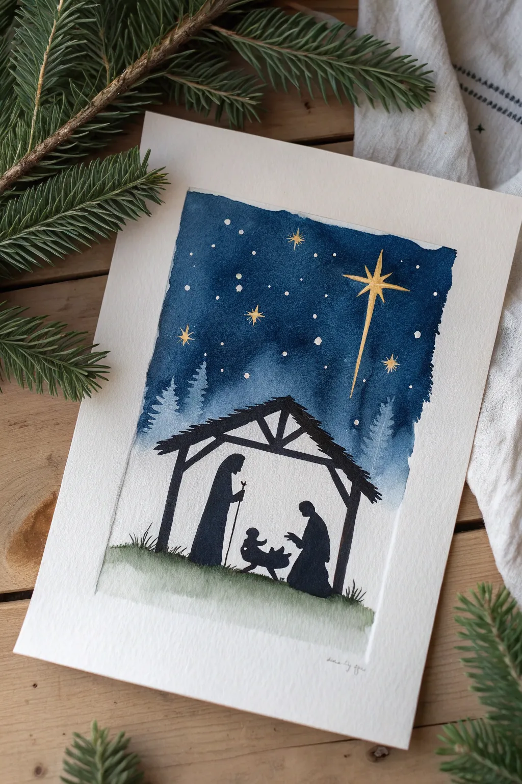 Minimal nativity silhouette beneath an indigo starry sky, a serene Christmas gift painting idea