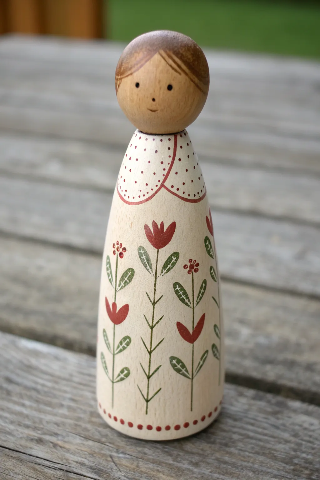 Folk florals on a painted peg doll apron, Scandinavian minimal style with a soft boho touch.