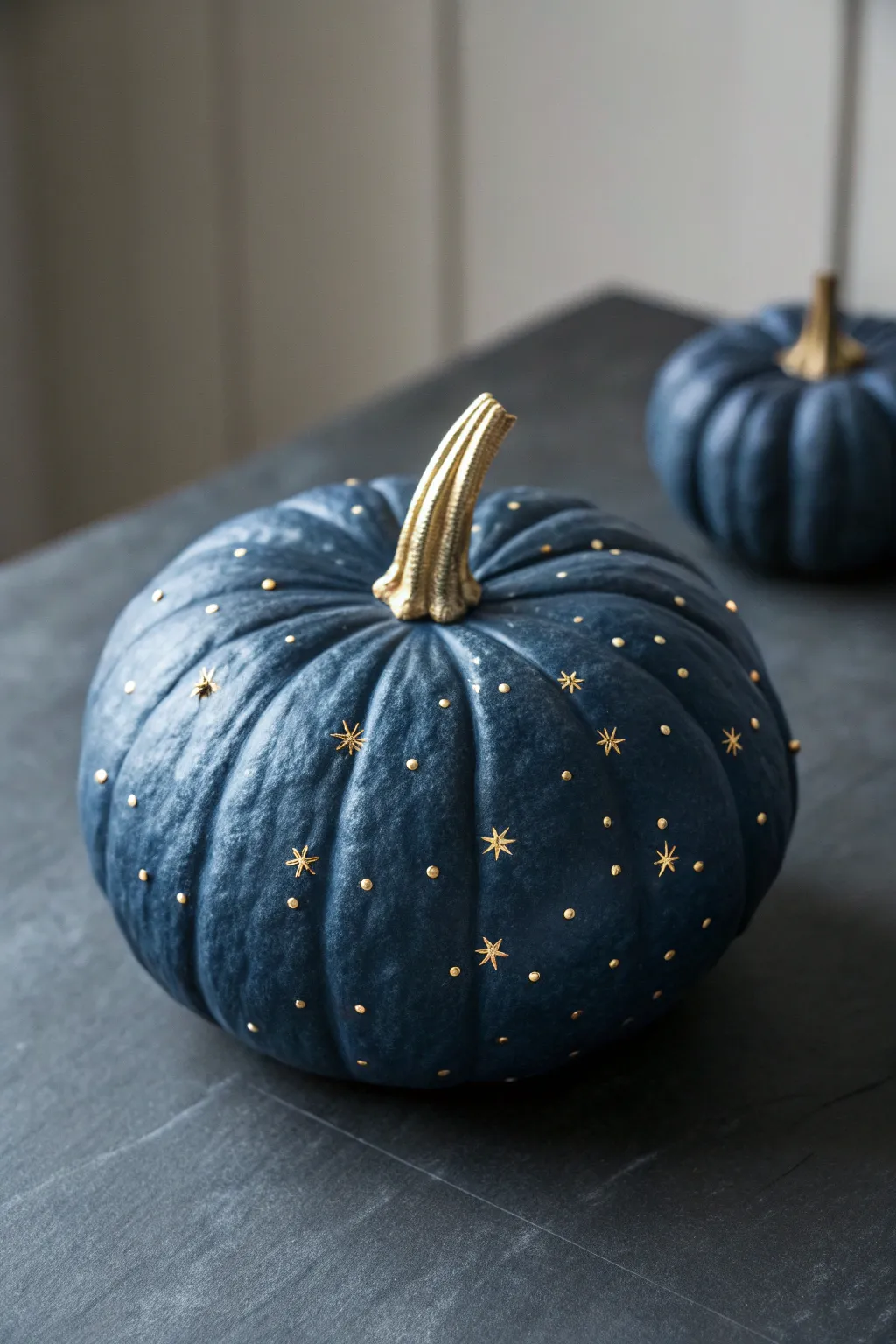 Deep navy constellation pumpkin with metallic star details, moody light, minimalist autumn vibe