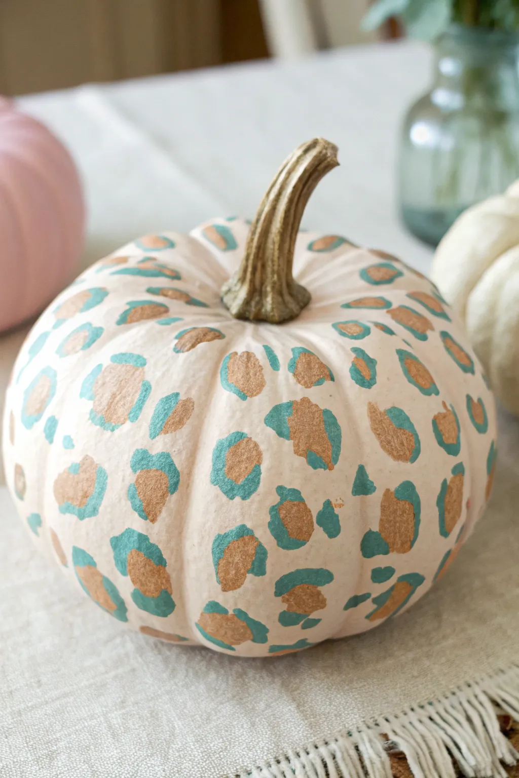Muted leopard print pumpkin in blush and teal for chic, minimalist fall decor with boho flair