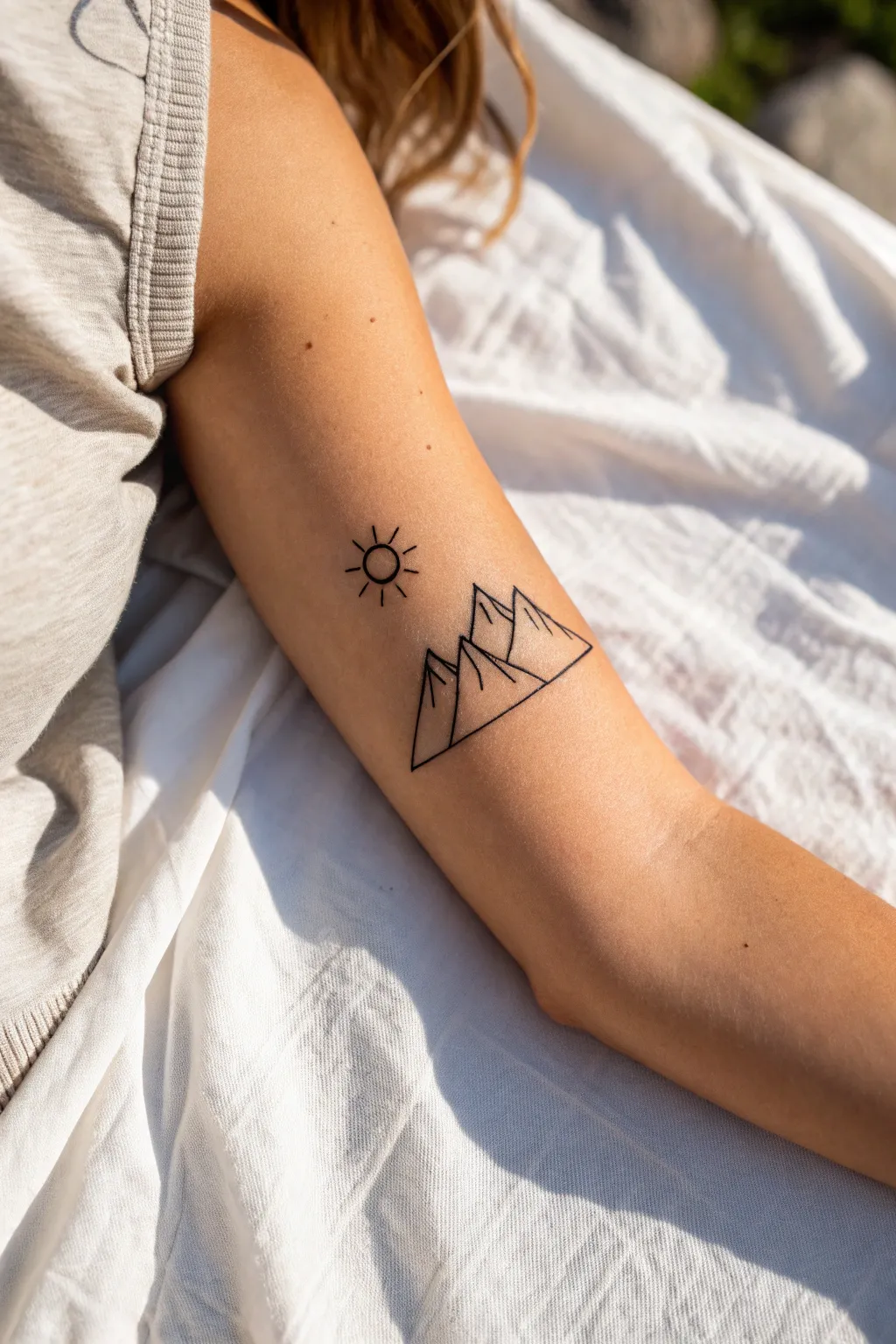Mini mountain outline tattoo with tiny sun, minimalist and boho, perfect small ink inspiration