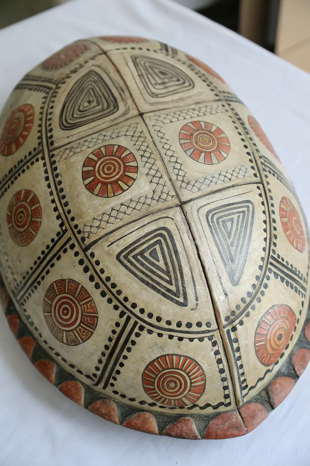Tribal dotwork panels on a turtle shell, minimalist boho palette with crisp contrast and detail.