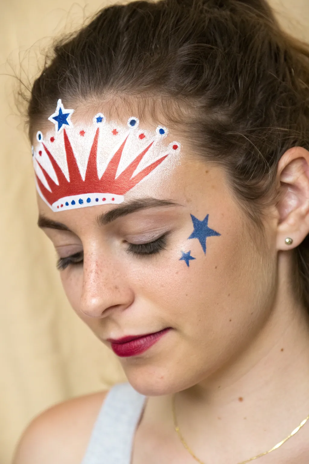 Easy 4th of July mini liberty crown forehead paint with stars, crisp and minimalist.