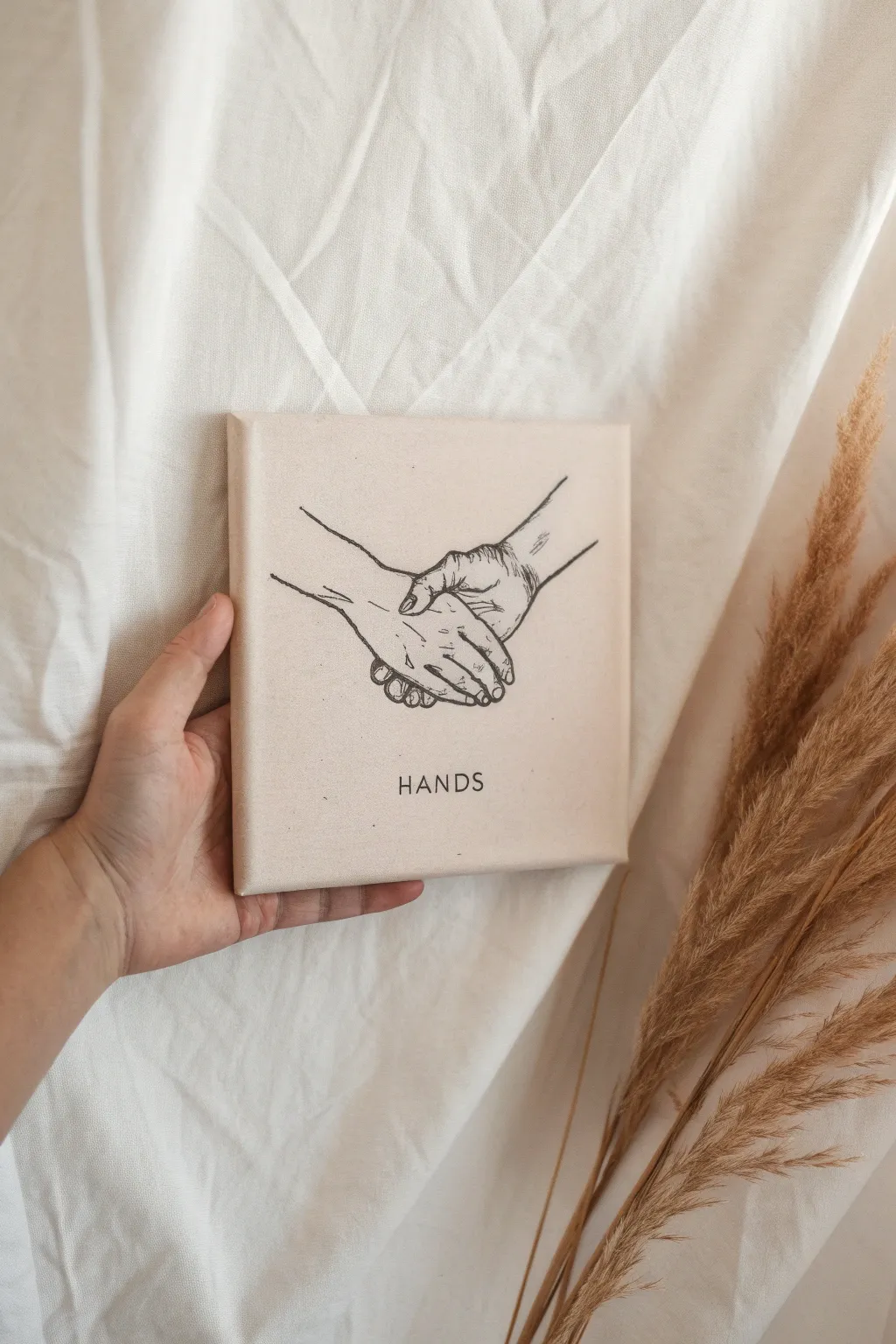 Intertwined hands line art on a soft wash canvas, a minimalist anniversary painting idea