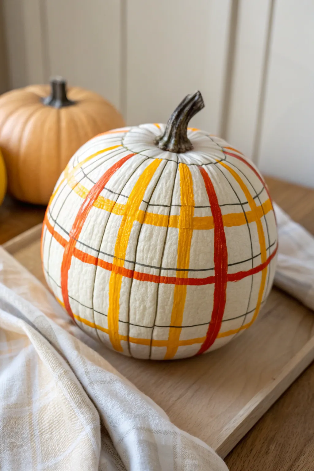 Cozy candy corn plaid pumpkin in minimalist fall tones, perfect for a simple DIY paint session