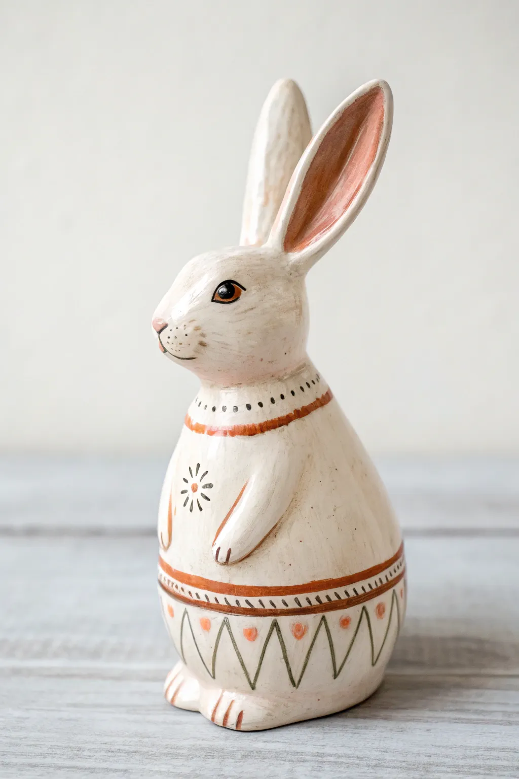 Folk art ceramic bunny with scallops and border bands, crisp contrast on a clean backdrop
