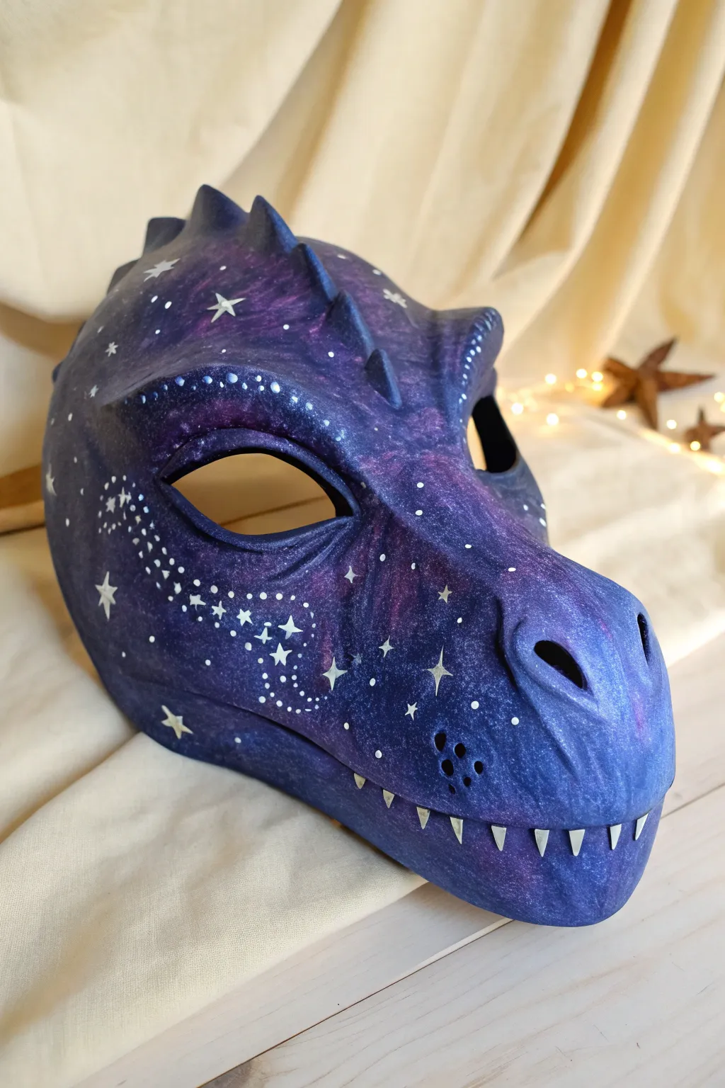 Cosmic galaxy dino mask in deep navy and purple, star-splattered with soft glowing highlights