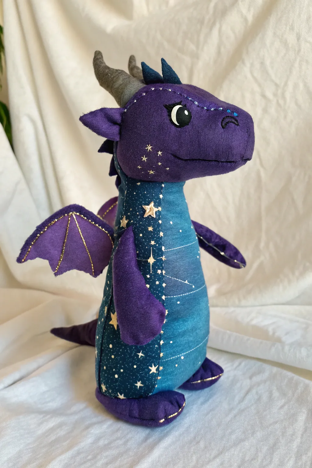 Galaxy dragon puppet in deep violet blues with starry paint and metallic dots, clean Nordic backdrop.