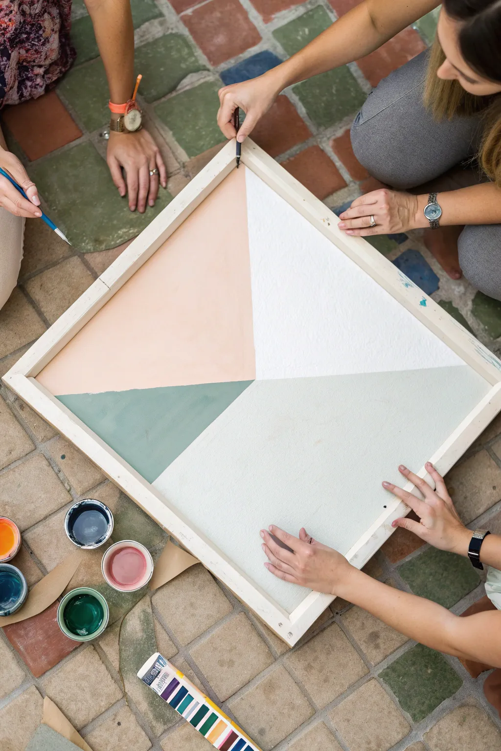 Paint swap round robin: one canvas in focus as friends trade works mid-process together.