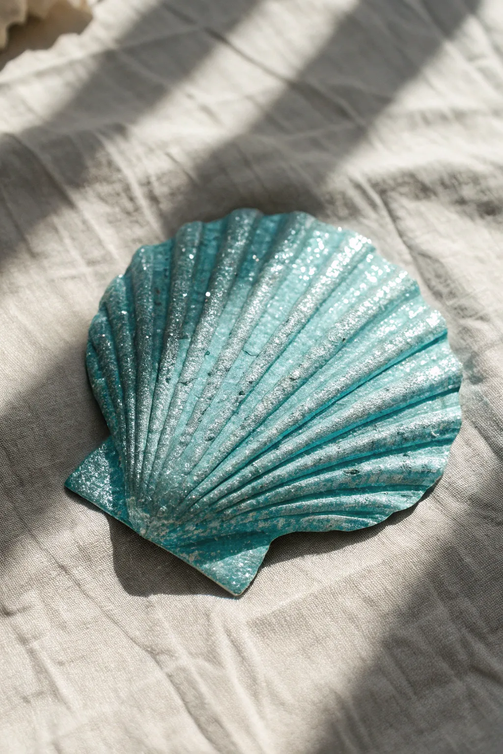 Elevate your coastal decor with these chic turquoise and silver glitter-dipped shells.