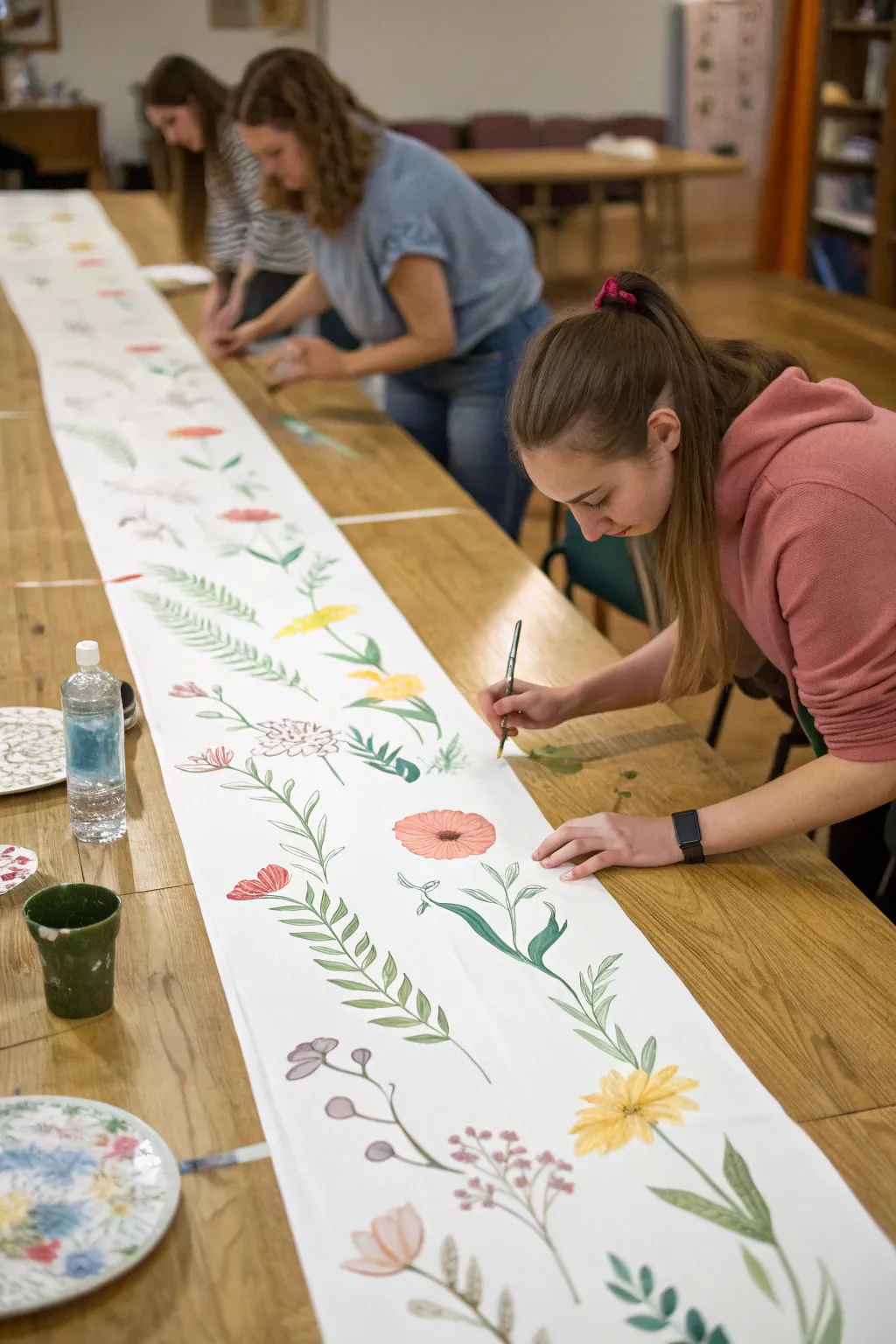 Paint a shared table runner with friends, layering flowers and washes for a cozy girls night.