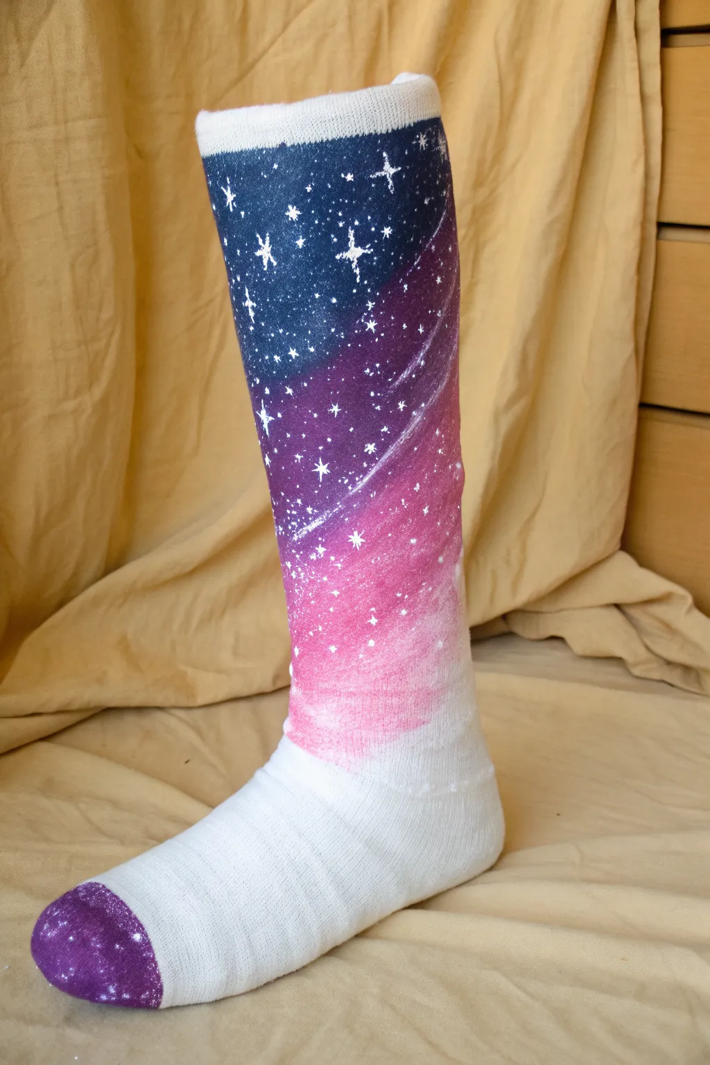 Galaxy gradient night sky painted on a leg cast, minimal styling, crisp contrast, dreamy stars