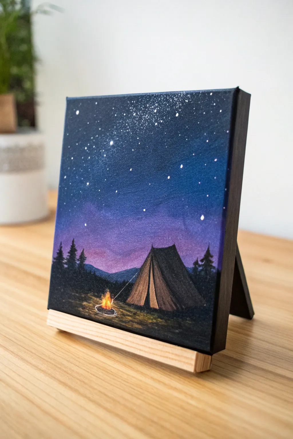 Mini canvas campsite silhouette with a warm campfire glow under a calm, starry gradient sky