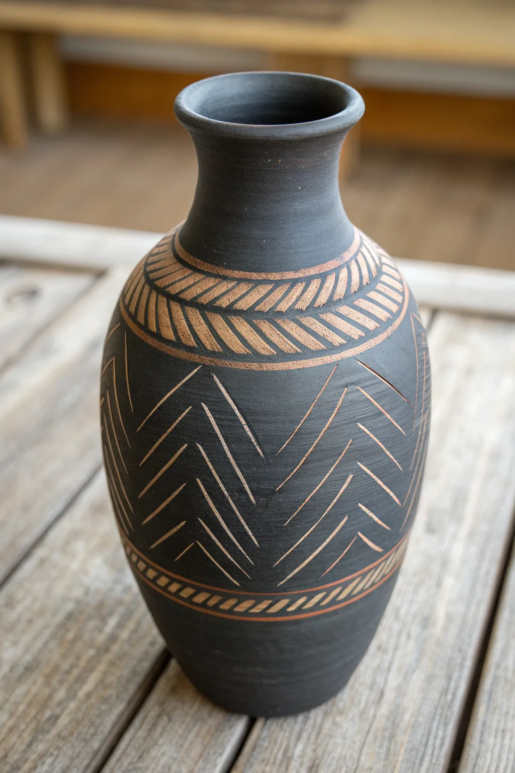 Sgraffito mud vase: dark paint scratched away to reveal warm clay in simple handmade patterns.