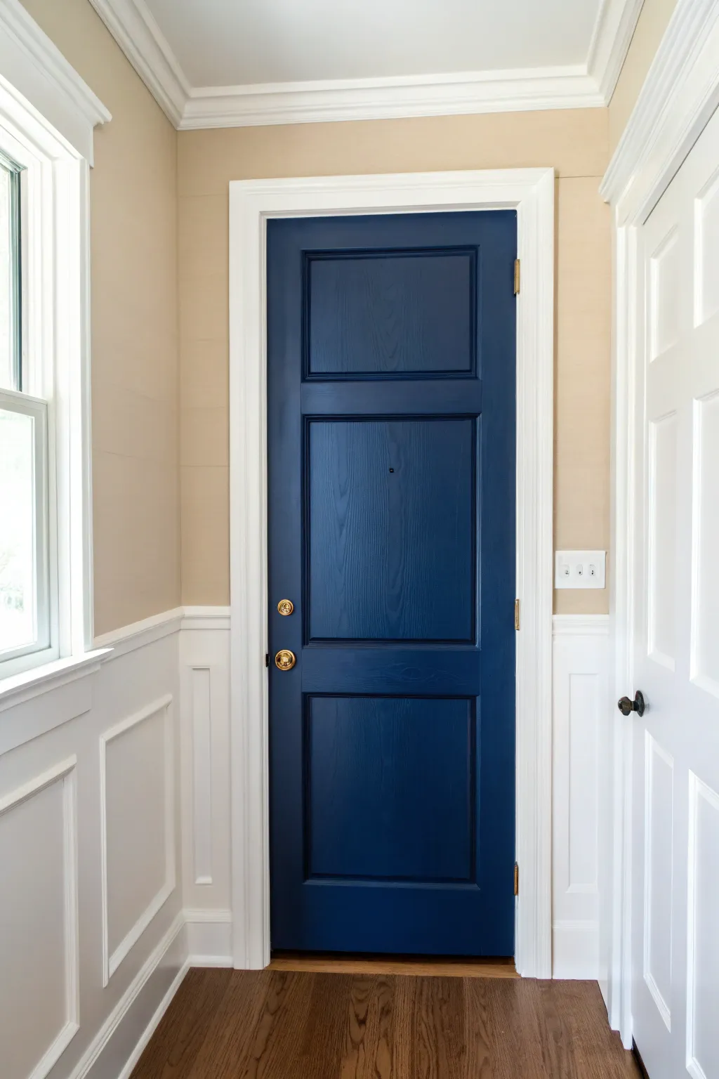 Deep blue door framed by crisp white trim for a bold, gallery-like hallway moment.