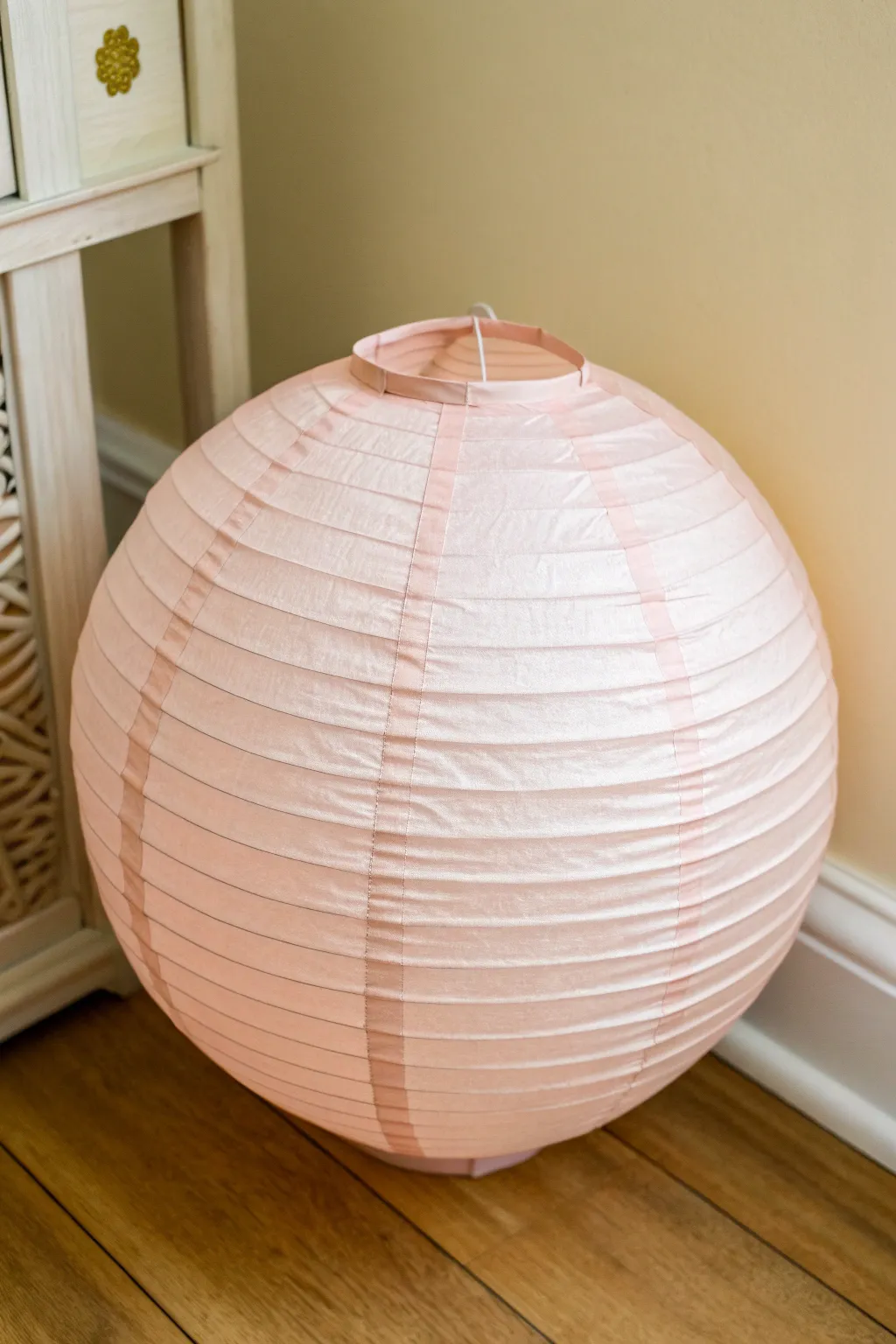 Pastel scallop-painted paper lantern for a soft boho glow in a minimalist Scandinavian nook