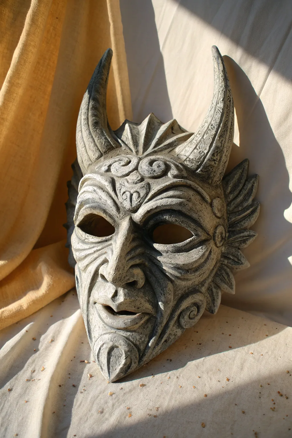 Aged stone gargoyle plaster mask in moody side light, highlighting carved shadows and texture