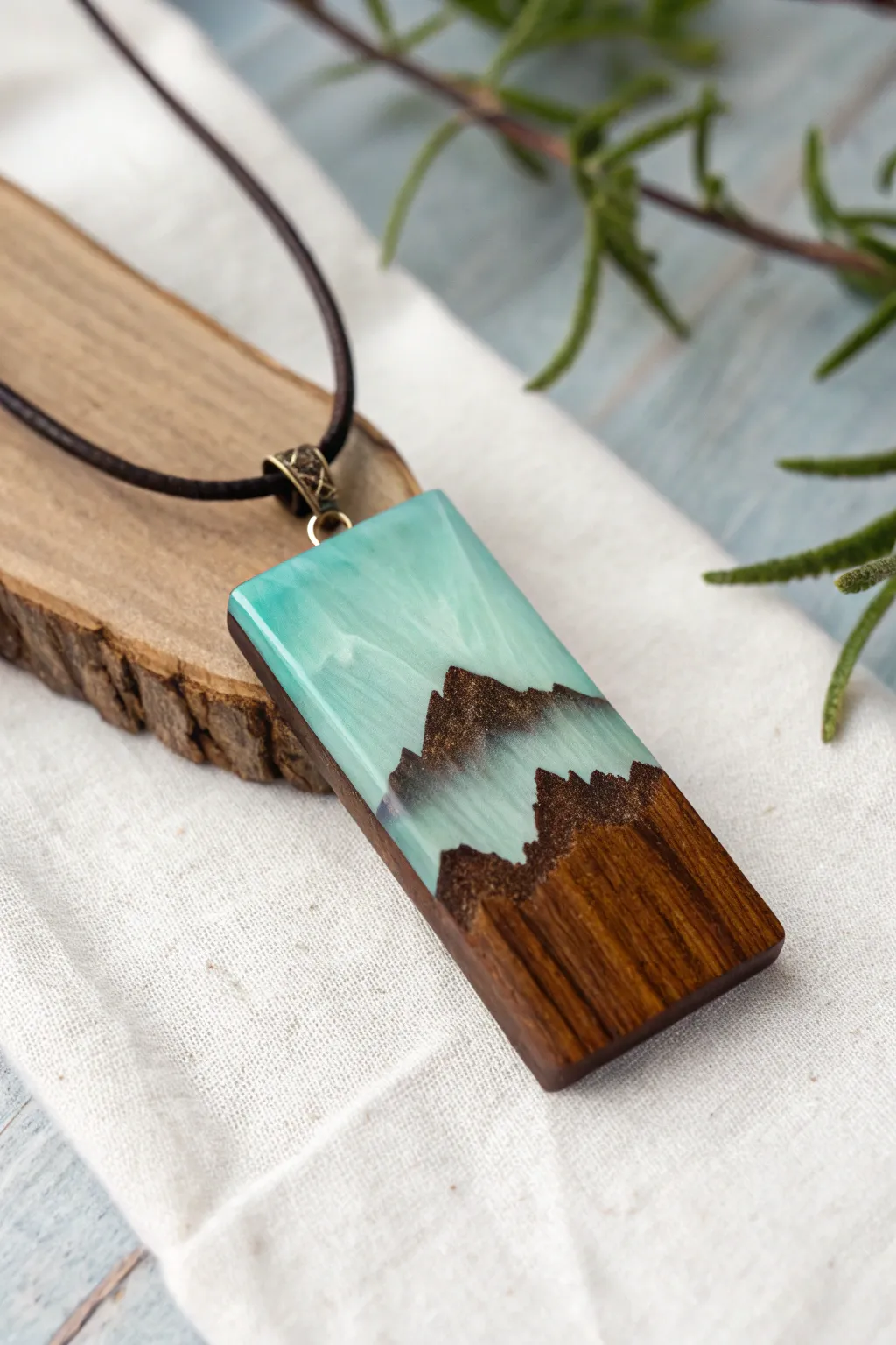 Minimal wood and resin mountain pendant with a dreamy tinted sky and clean Scandinavian contrast.