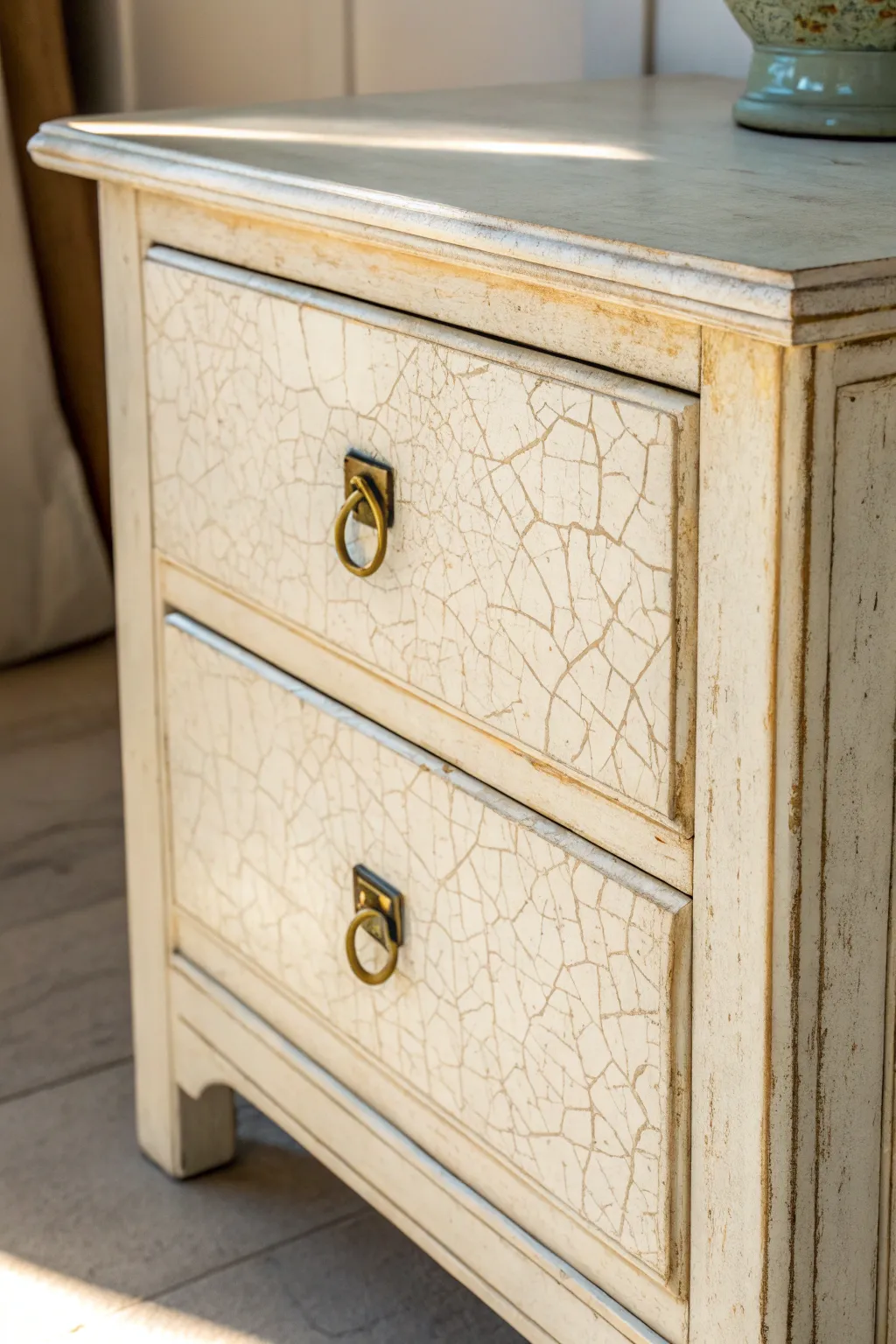 Fine crackle texture on a neutral drawer front, softly lit to highlight shabby chic charm