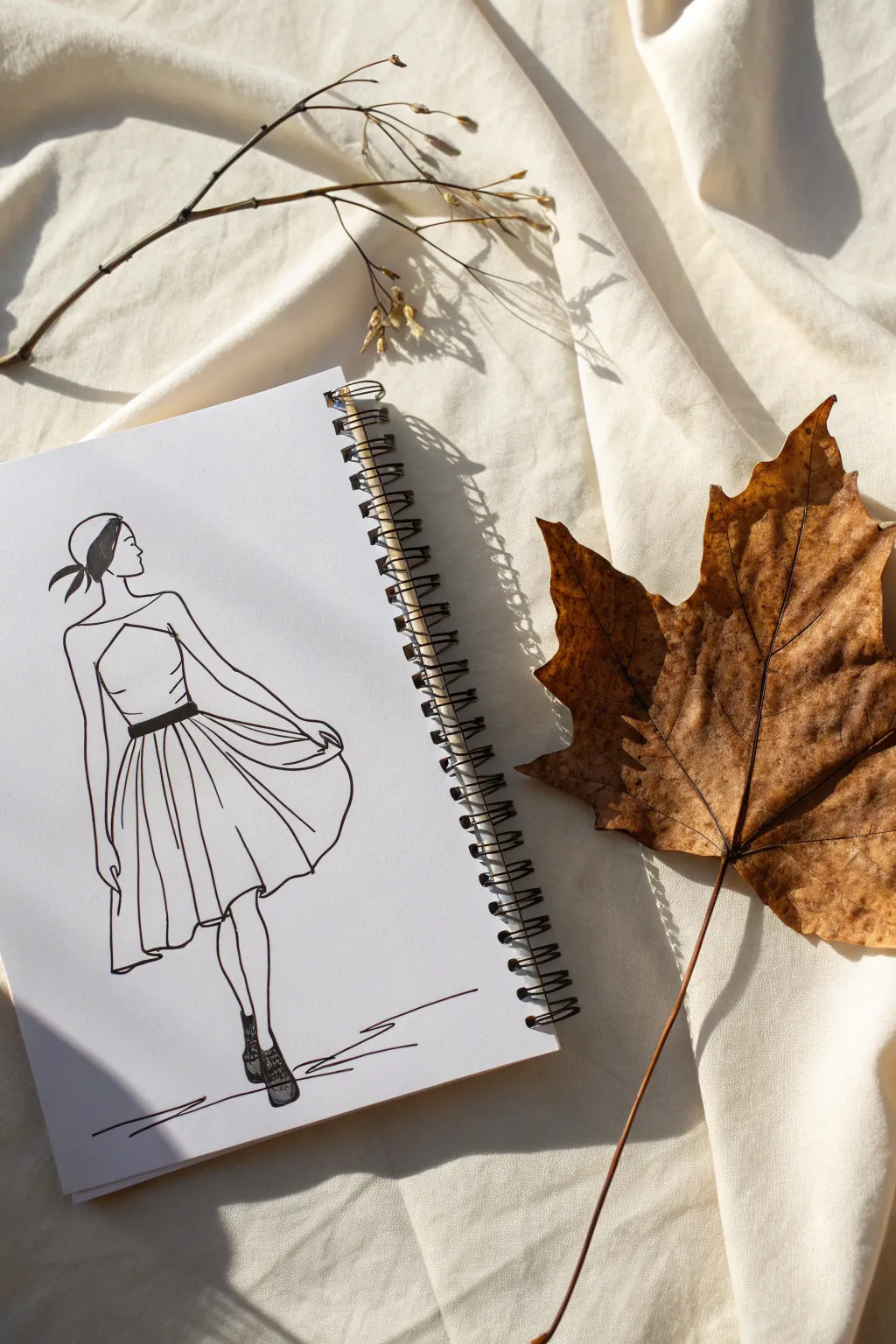 A real leaf completes a simple sketch, creating a playful found-object fashion illusion.
