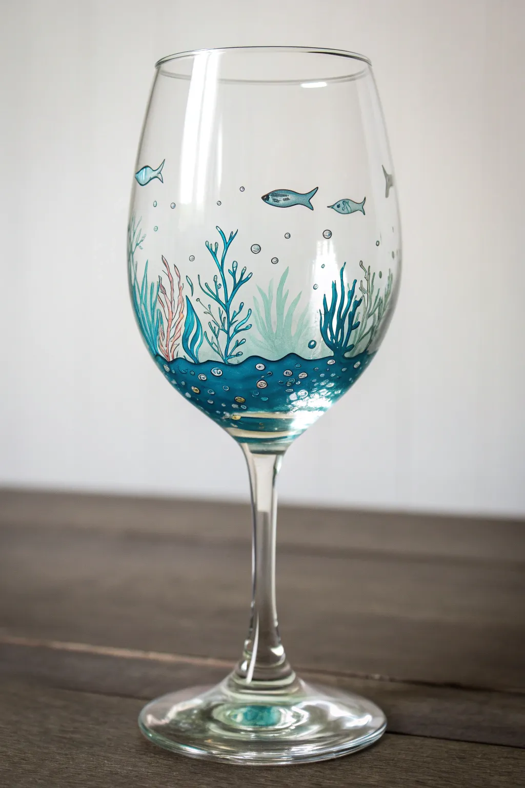 DIY wine glass art: a minimalist teal ocean wrap with fish, bubbles, and seaweed