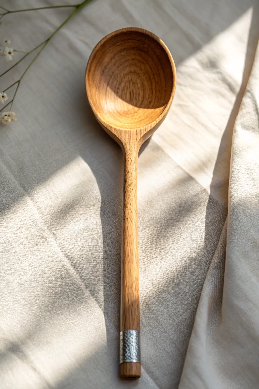 Minimal wooden spoon with metallic tip and rim, glowing softly in warm Scandinavian light