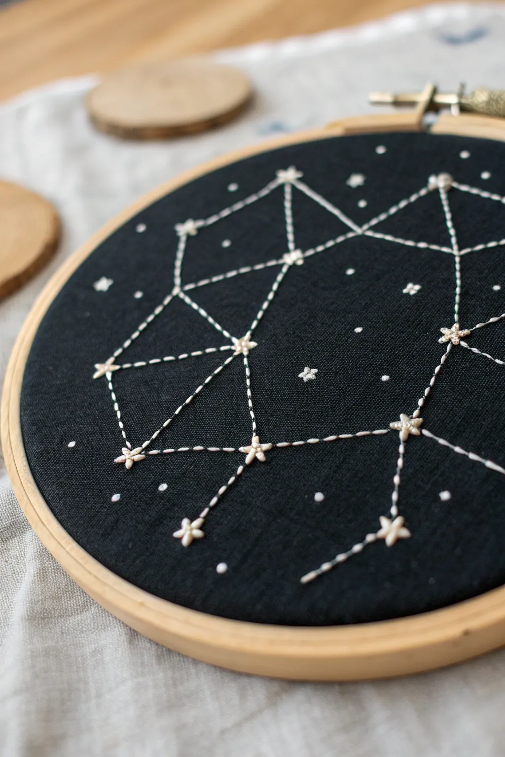 Minimalist yarn constellation on black linen, softly lit for a dreamy night sky craft mood