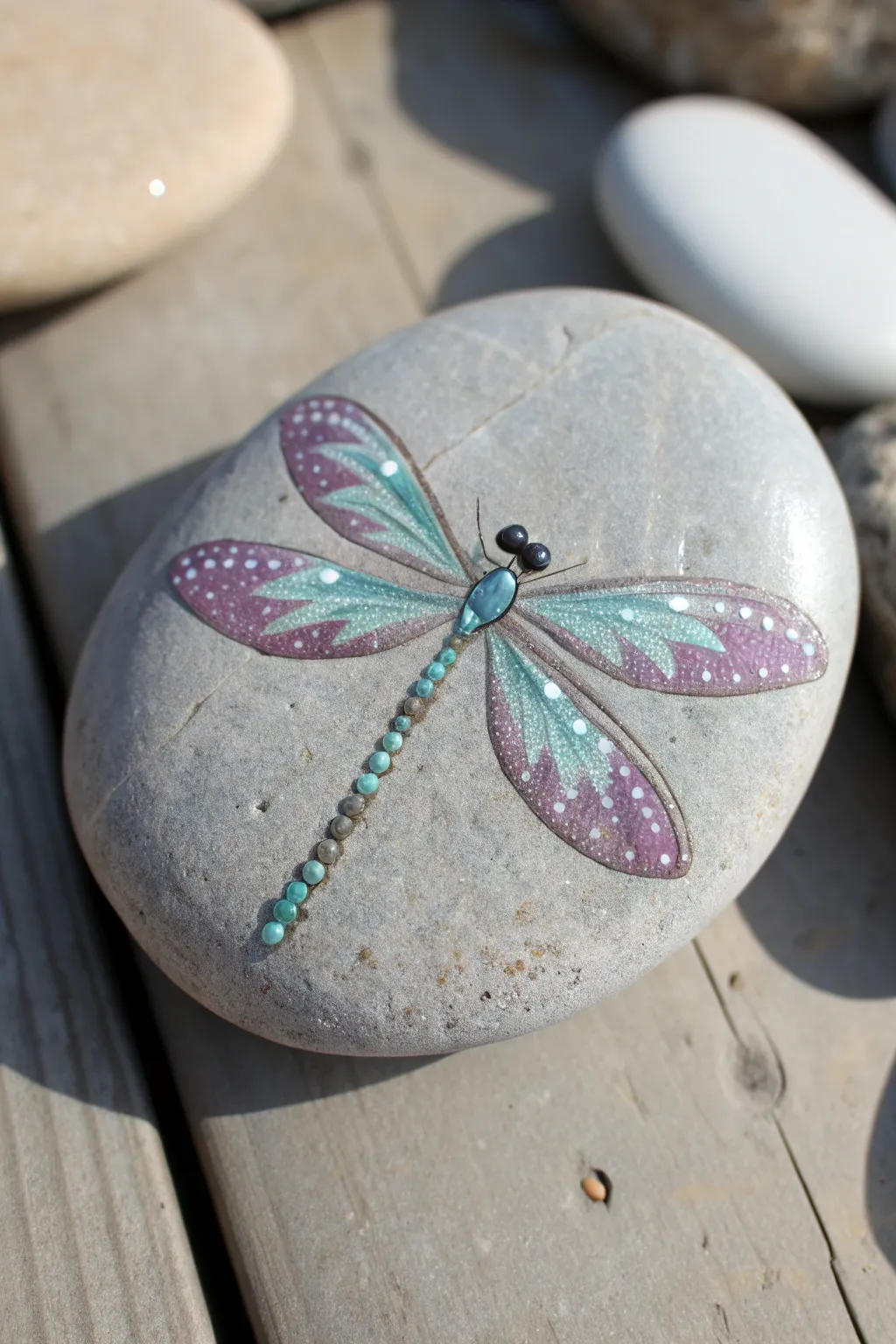 Shimmering dragonfly wings on a painted rock, minimalist boho vibes for easy DIY inspiration.
