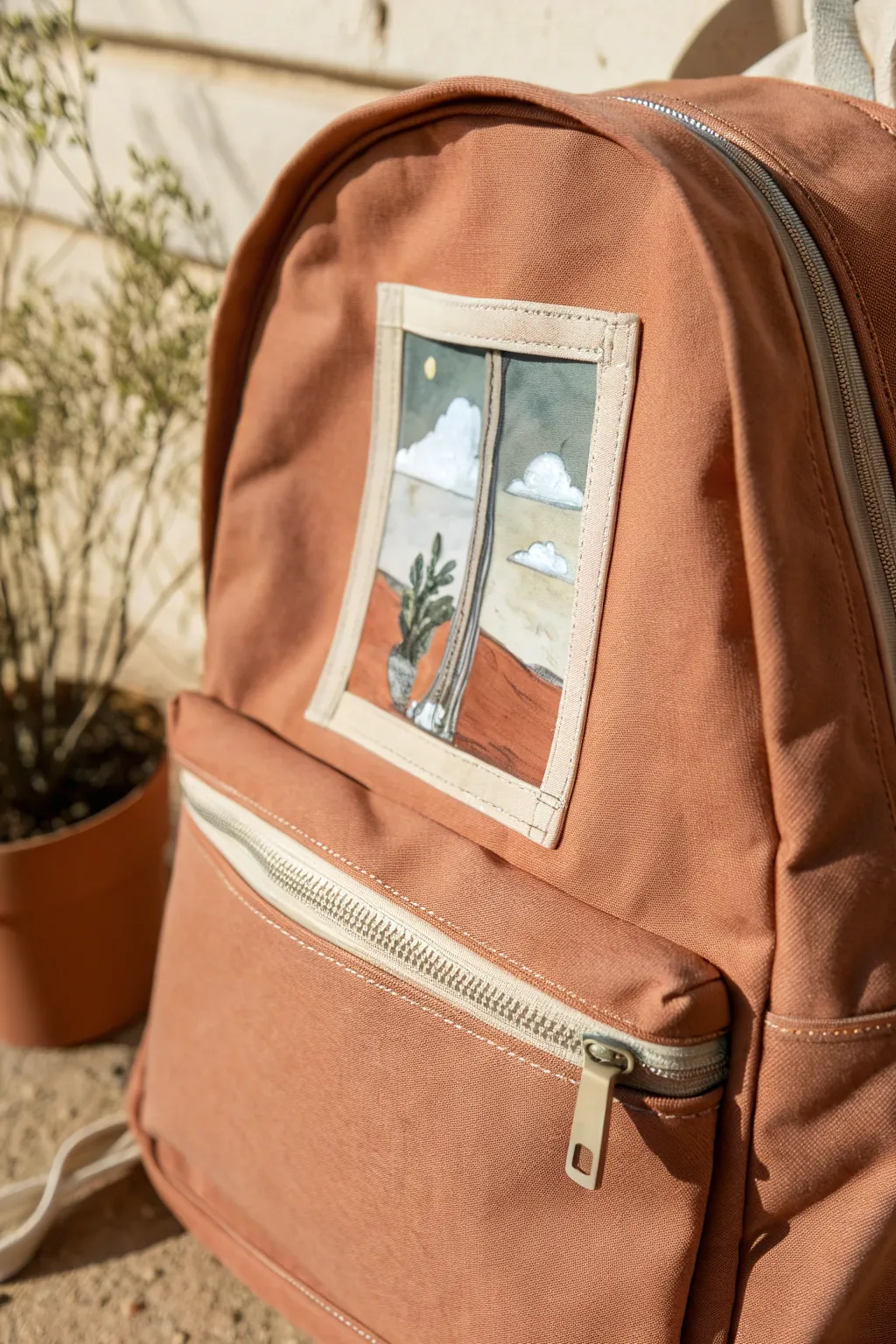 Zipper-framed tiny scene on a backpack pocket, minimalist Scandinavian with a soft boho touch