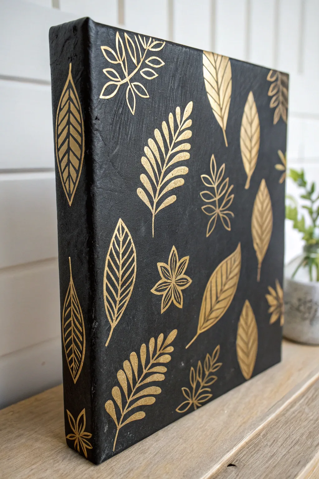Minimal black texture with handmade gold stencil leaves for chic Scandinavian boho contrast.