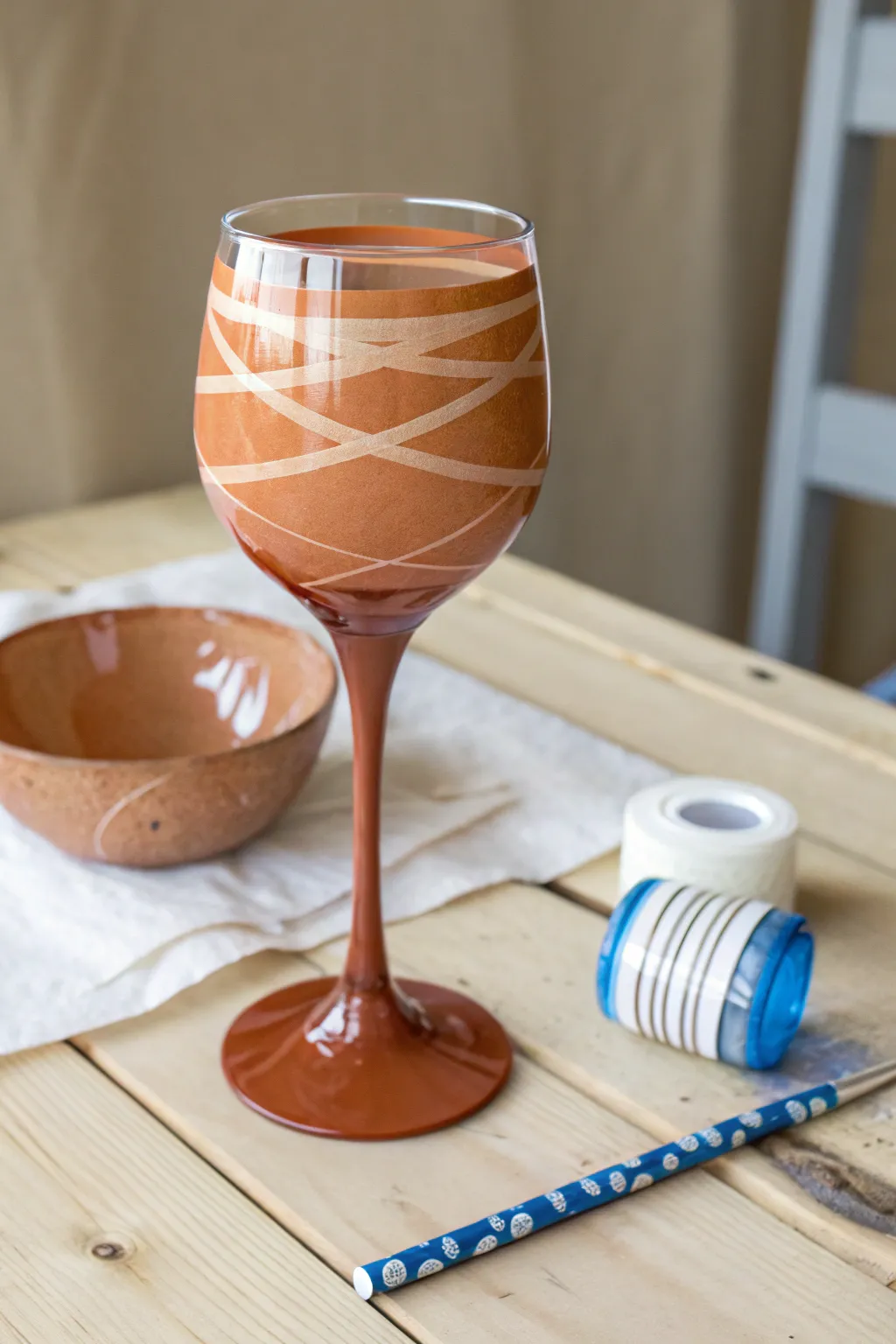 Crisp negative-space tape stripes turn a simple wine glass into modern DIY table art.