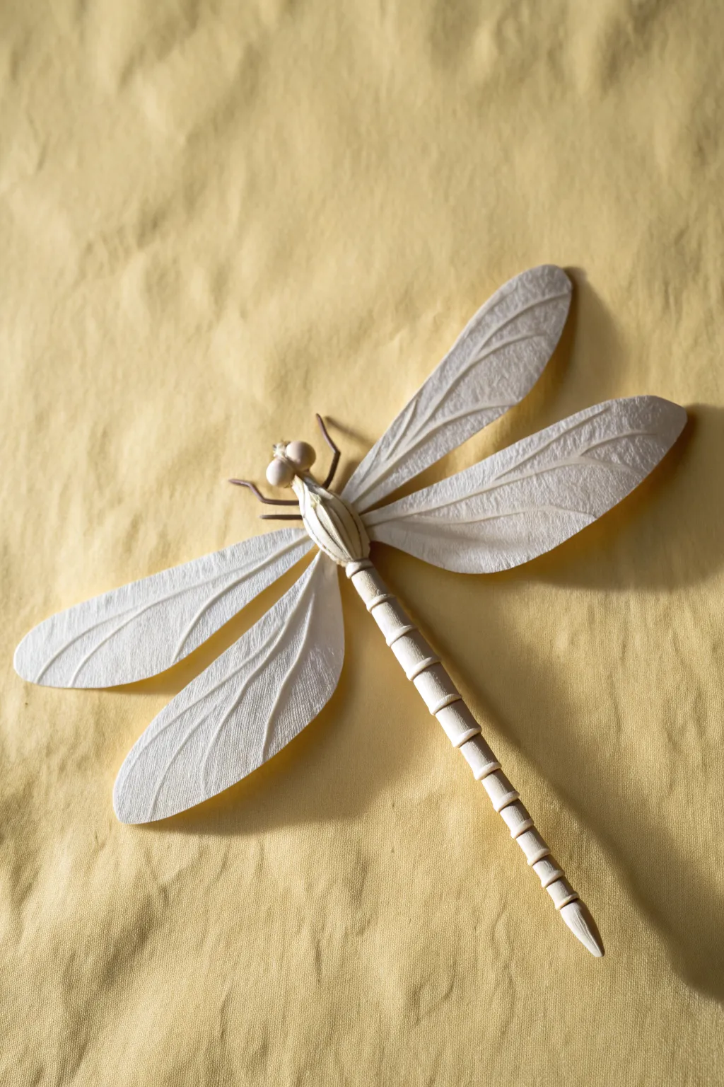 Lifted paper dragonfly wings create an easy 3D craft with soft shadows and clean Nordic style.