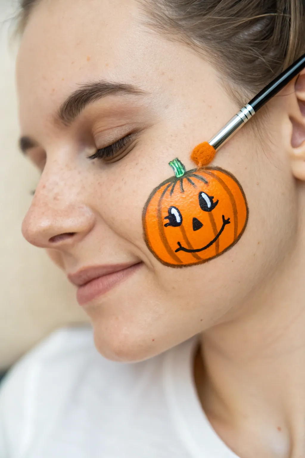 Tiny pumpkin cheek art: simple carved face, clean outline, cozy autumn vibe in one stroke.