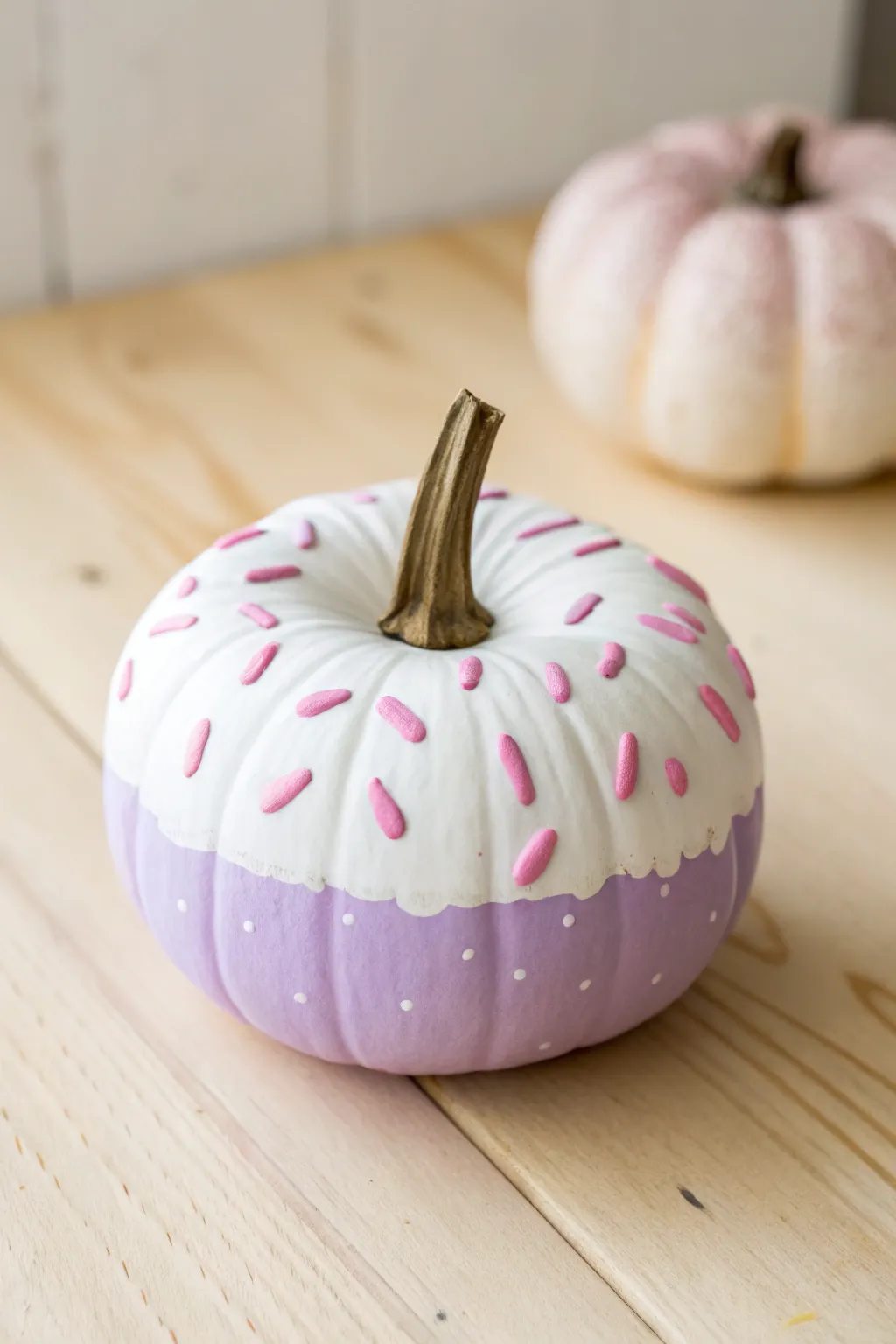 Donut-style frosted pumpkin in pastel paint, simple Scandinavian backdrop, cute kids craft.