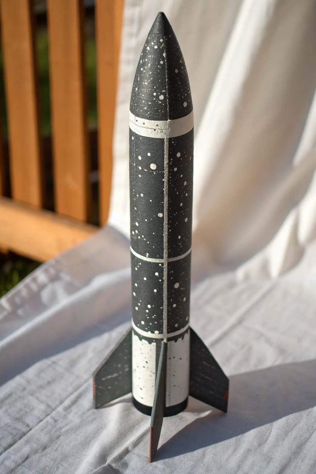 Meteor dust splatter on a dark model rocket, minimalist backdrop and crisp speckles in focus