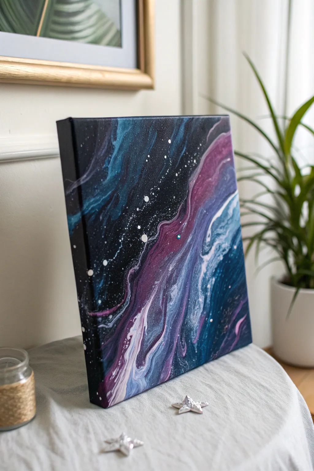 Dreamy galaxy pour canvas with bold swirls and starry splatters for an easy paint night vibe