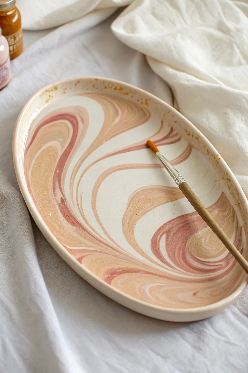 Loose marbled swirls in soft boho tones, captured mid-brush for an easy platter paint idea.