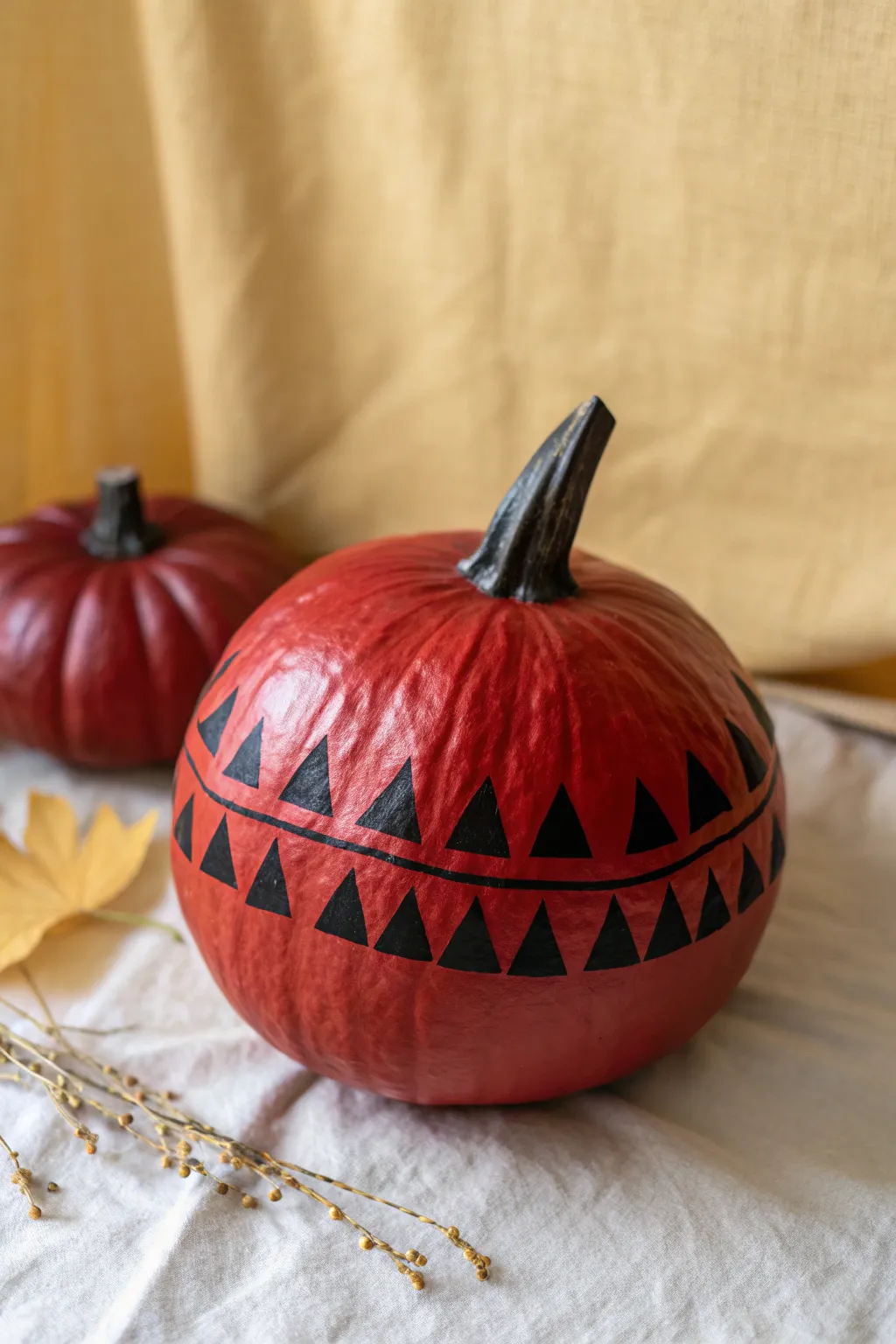 Modern red pumpkin with crisp black triangle tape shapes for a bold Scandinavian fall accent