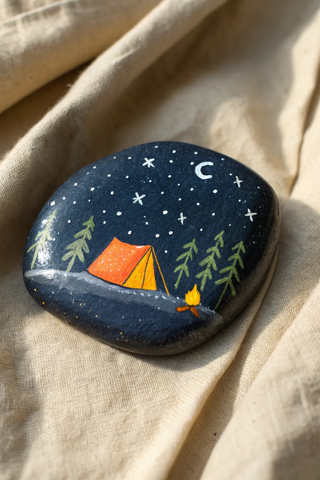 Capture the magic of summer nights with this dreamy camping rock painting idea.