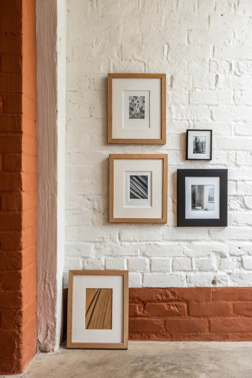 Paint a bold rectangular frame behind layered wall art to define a clean, cozy gallery zone