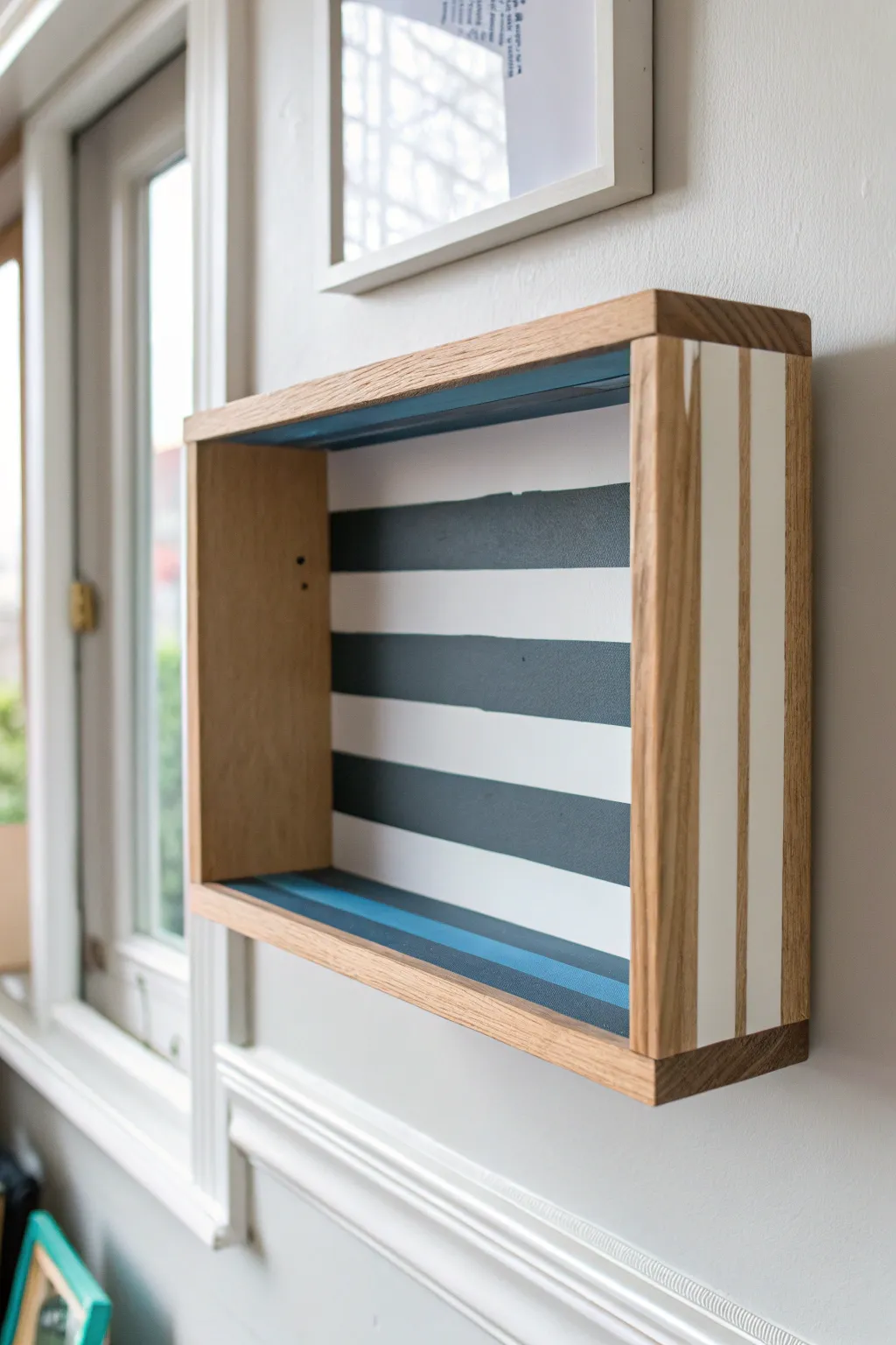 Crisp painter-tape stripes turn a simple shelf into a modern Scandinavian statement piece.