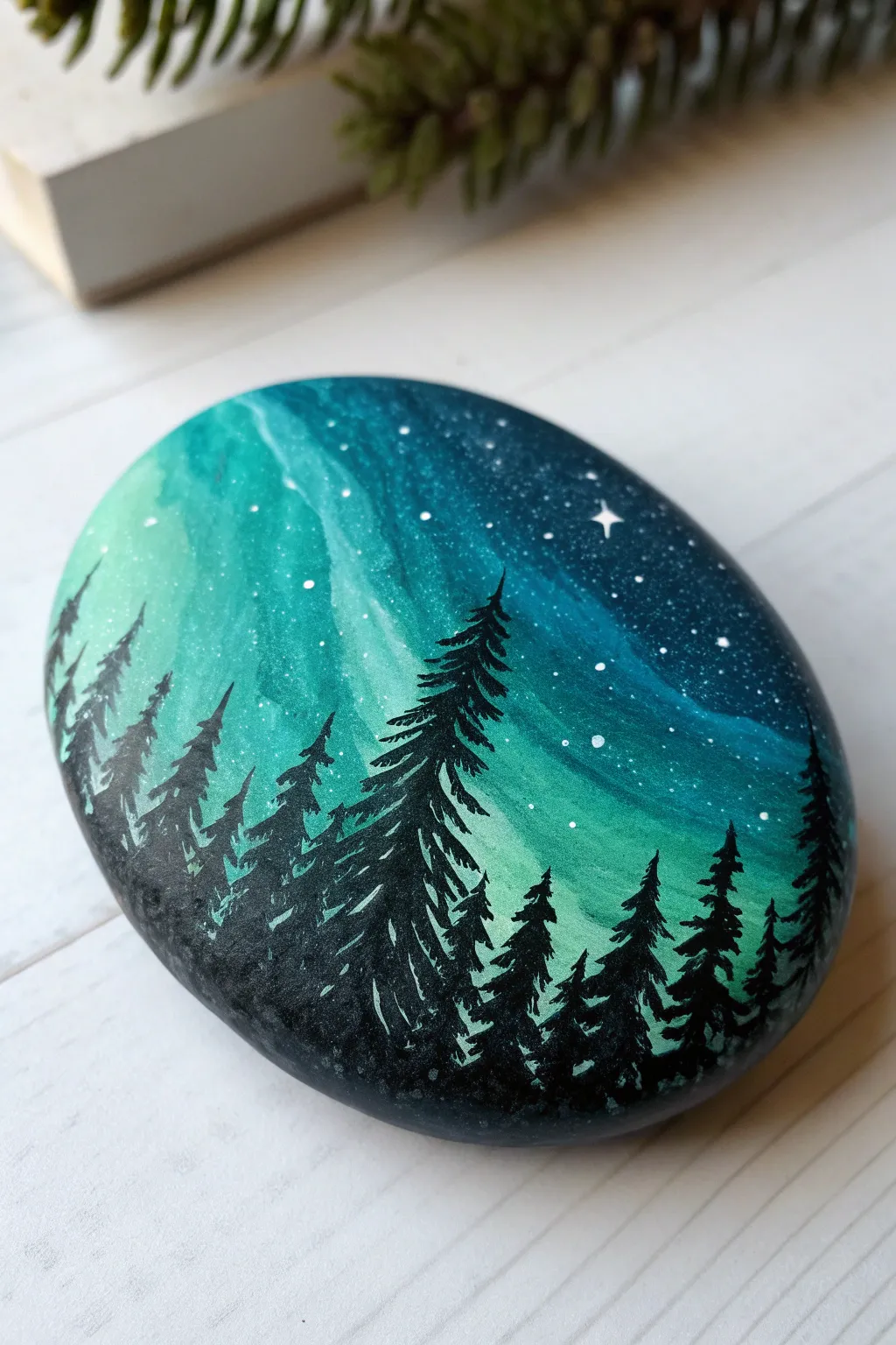 Paint a moody aurora sky on a smooth rock, finished with a crisp pine forest silhouette.