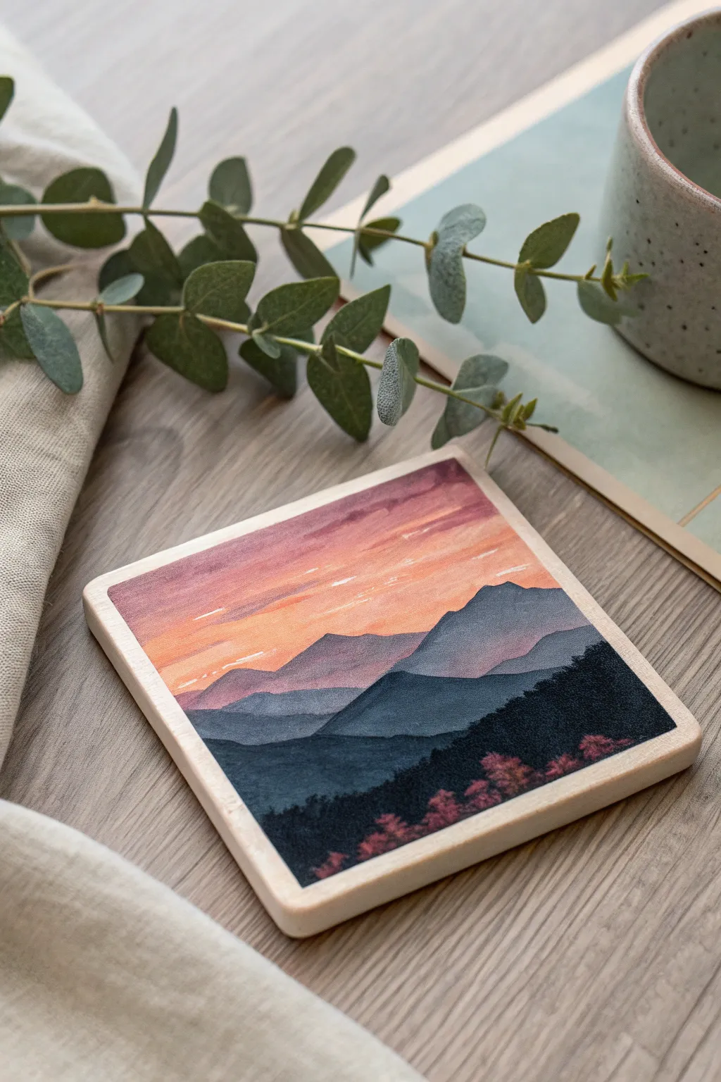 Mini mountain sunset on a square coaster with a soft gradient sky and crisp silhouettes.