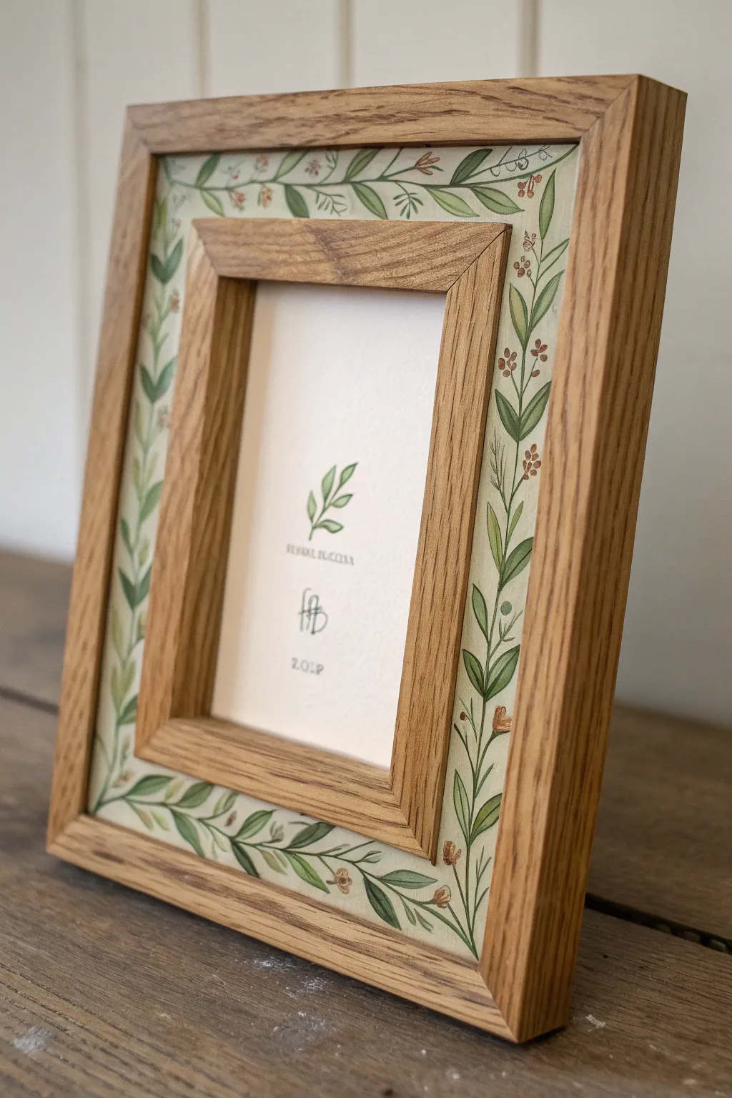 Minimal wooden frame with a hand-painted leafy garland border and a simple botanical sketch.