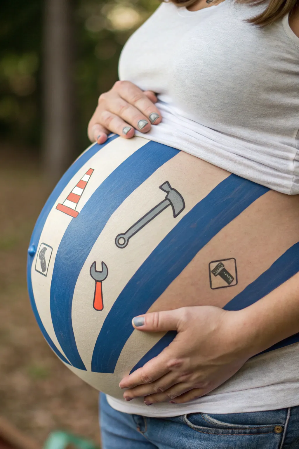 Bold blue and gray construction belly paint with tiny tool icons, minimalist boho style for baby boy