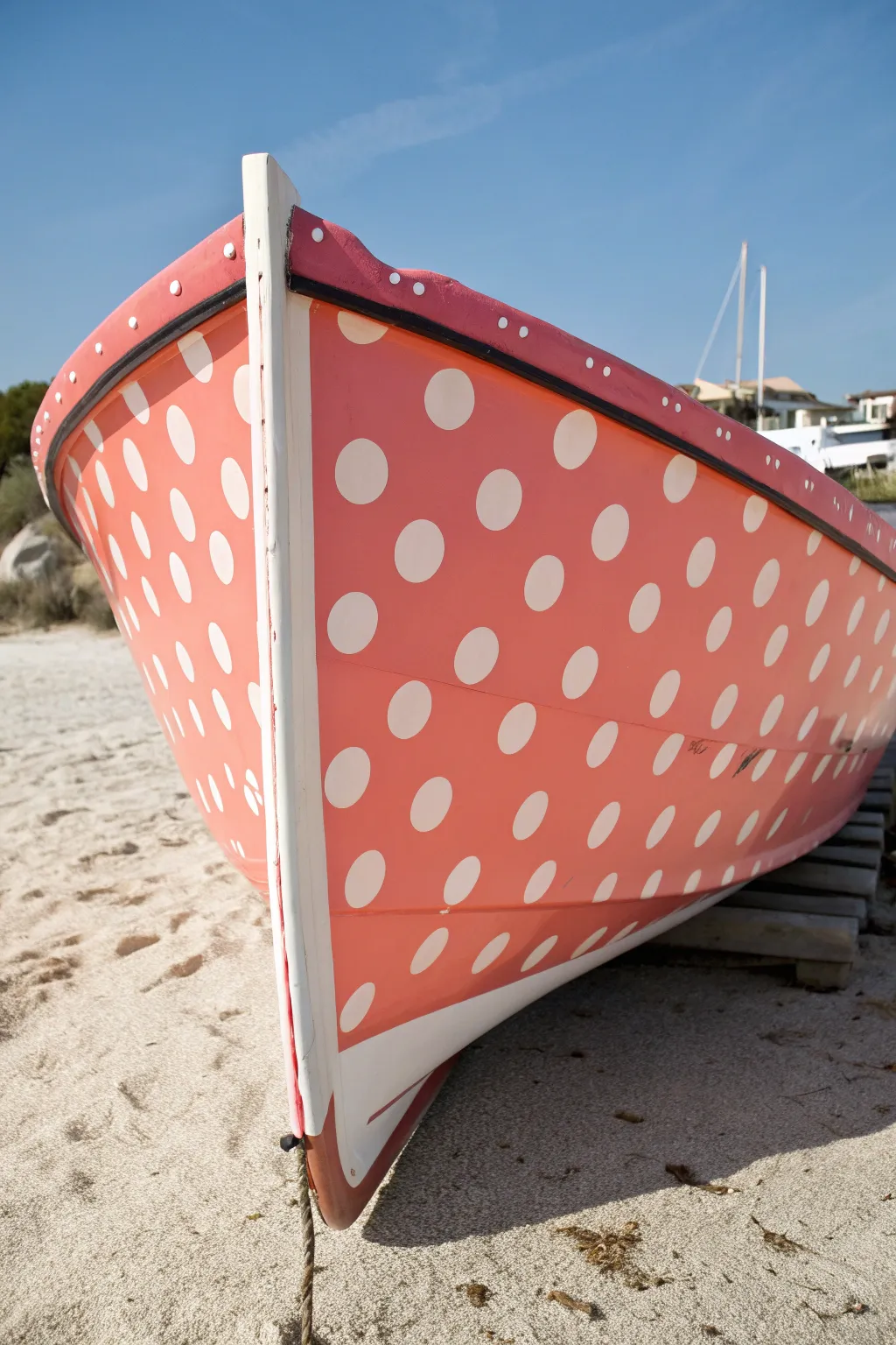 Bold pop-art polka dots with shaded edges create a striking cutout illusion on a boat hull.