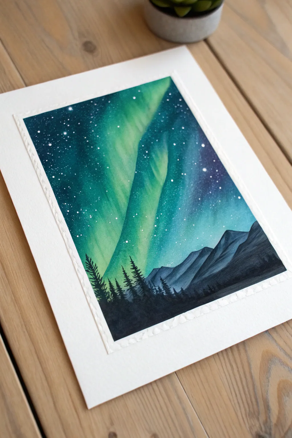 Simple aurora painting idea: glowing teal ribbons above crisp dark mountain silhouettes