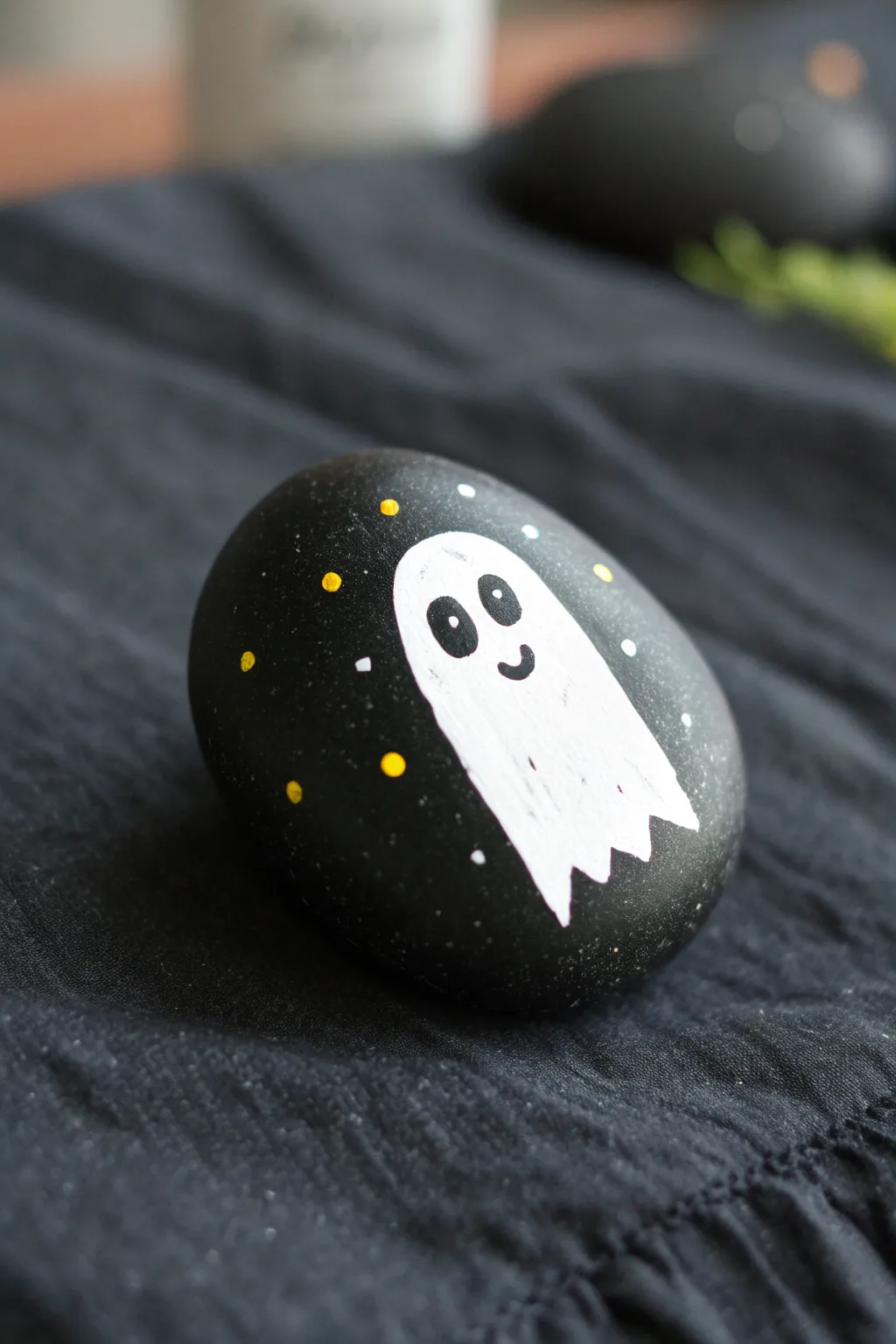 Glow-look ghost on a matte black rock for a striking, minimalist Halloween vibe