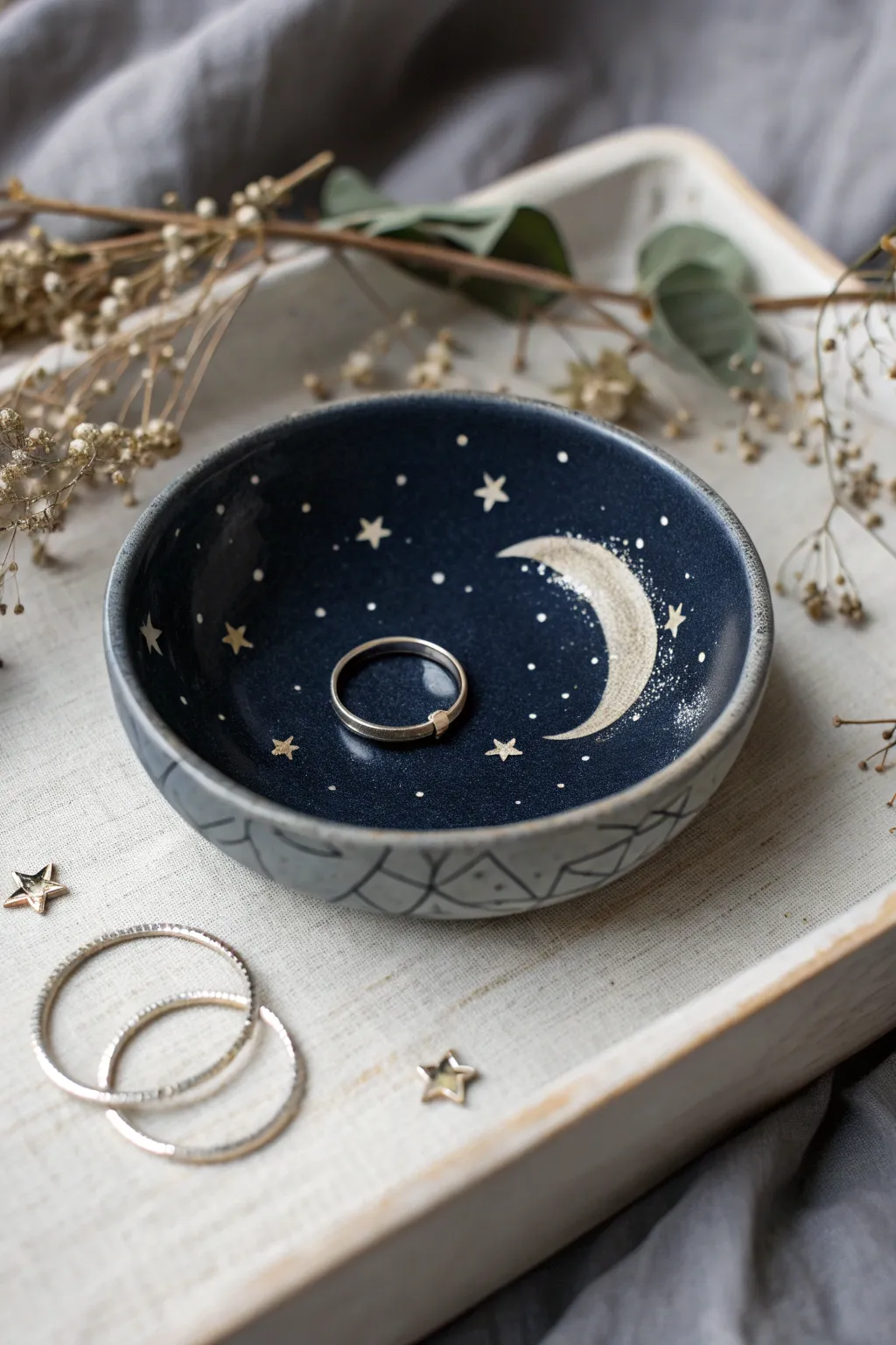 Moody midnight jewelry dish with moon, stars, and subtle metallic accents for dreamy minimal decor.