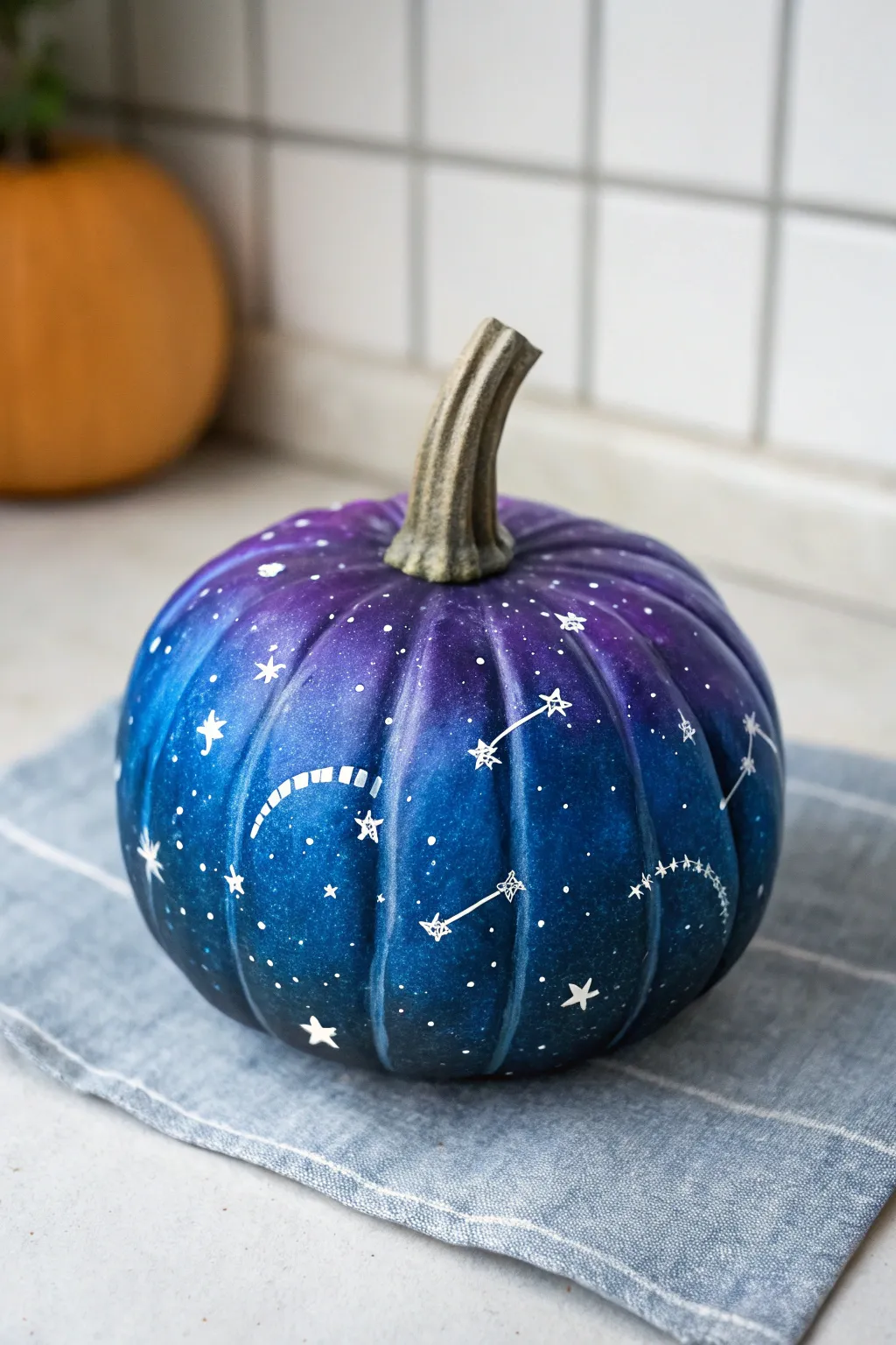 Galaxy starfield mini pumpkin in navy, violet, and blue with crisp white stars for dreamy fall decor.